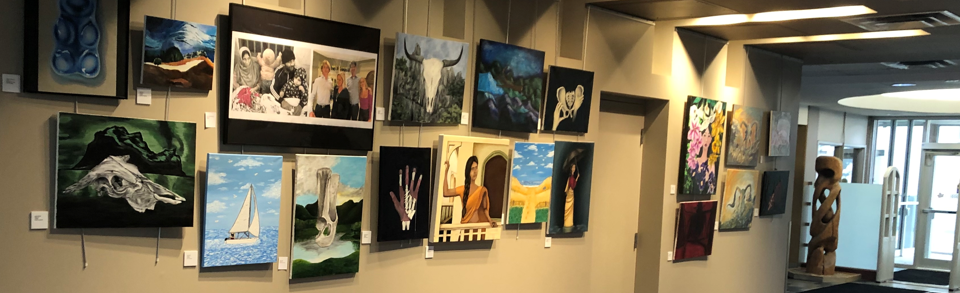 Wall with a variety of paintings on it