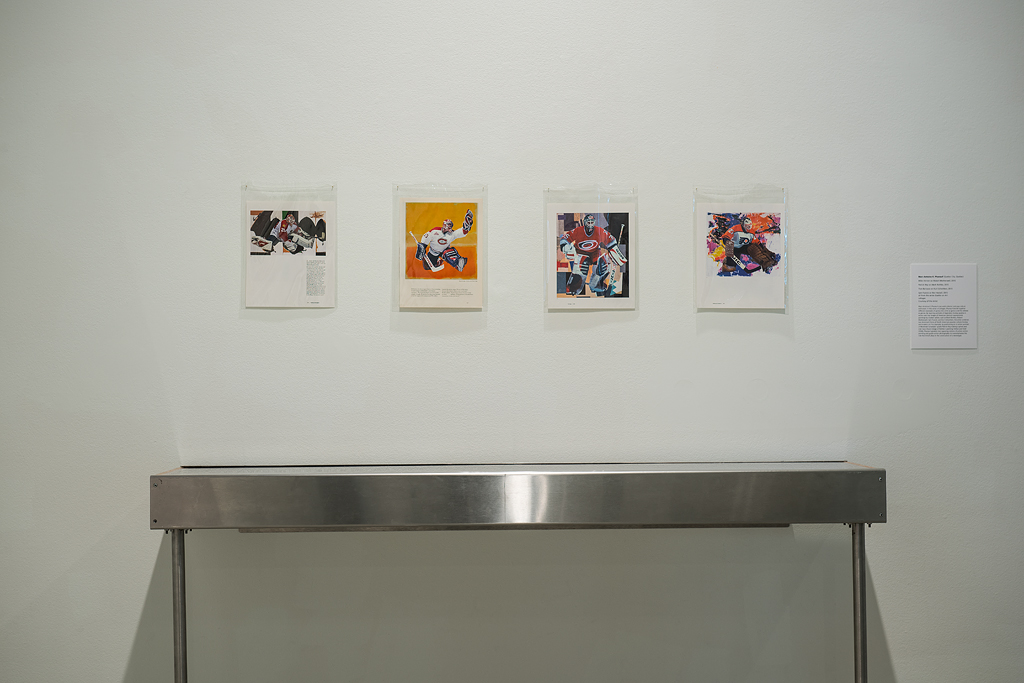 Installation image of four collages of NHL goalies positioned overtop reproductions of abstract paintings by Robert Motherwell, Mark Rothko, and Kurt Schwitters. The four works hang in a horizontal row overtop a display case.
