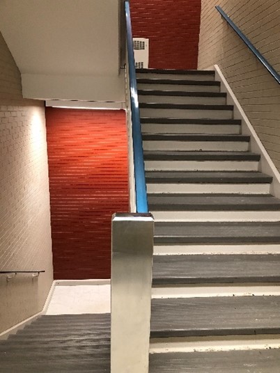 Stairwell up and down, with handrails.