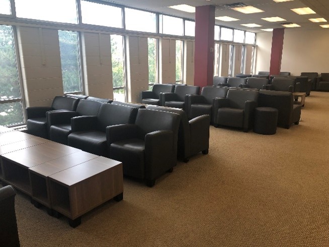 Sets of comfy chairs near some windows. The chairs are in sets of four. Some have large coffee table. 