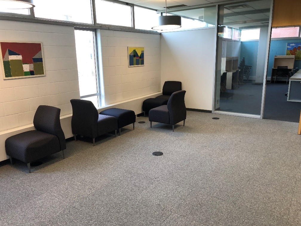 The second area of the graduate lounge. There are cushiony chairs, lower to the ground