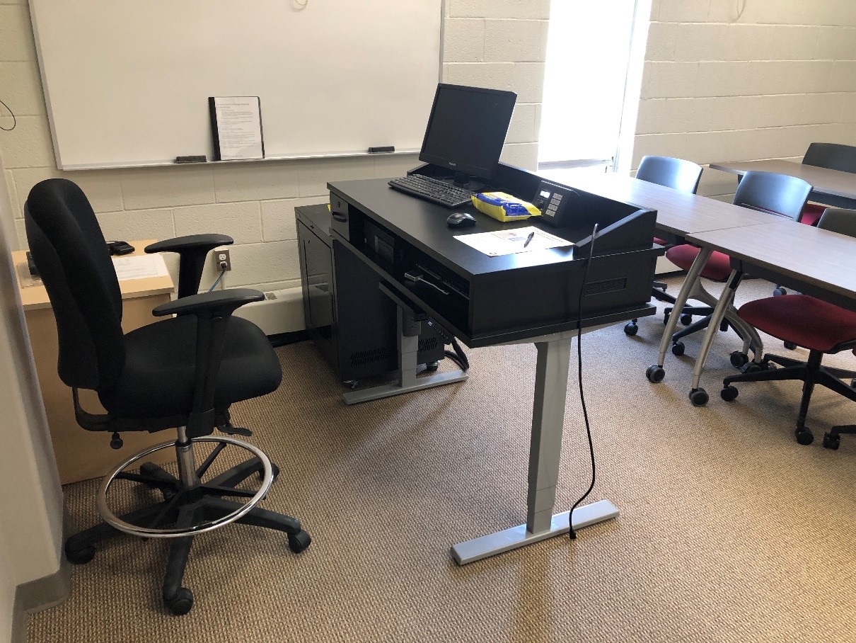 The desk for the instructor at the front of room. The desk can be raised or lowered.