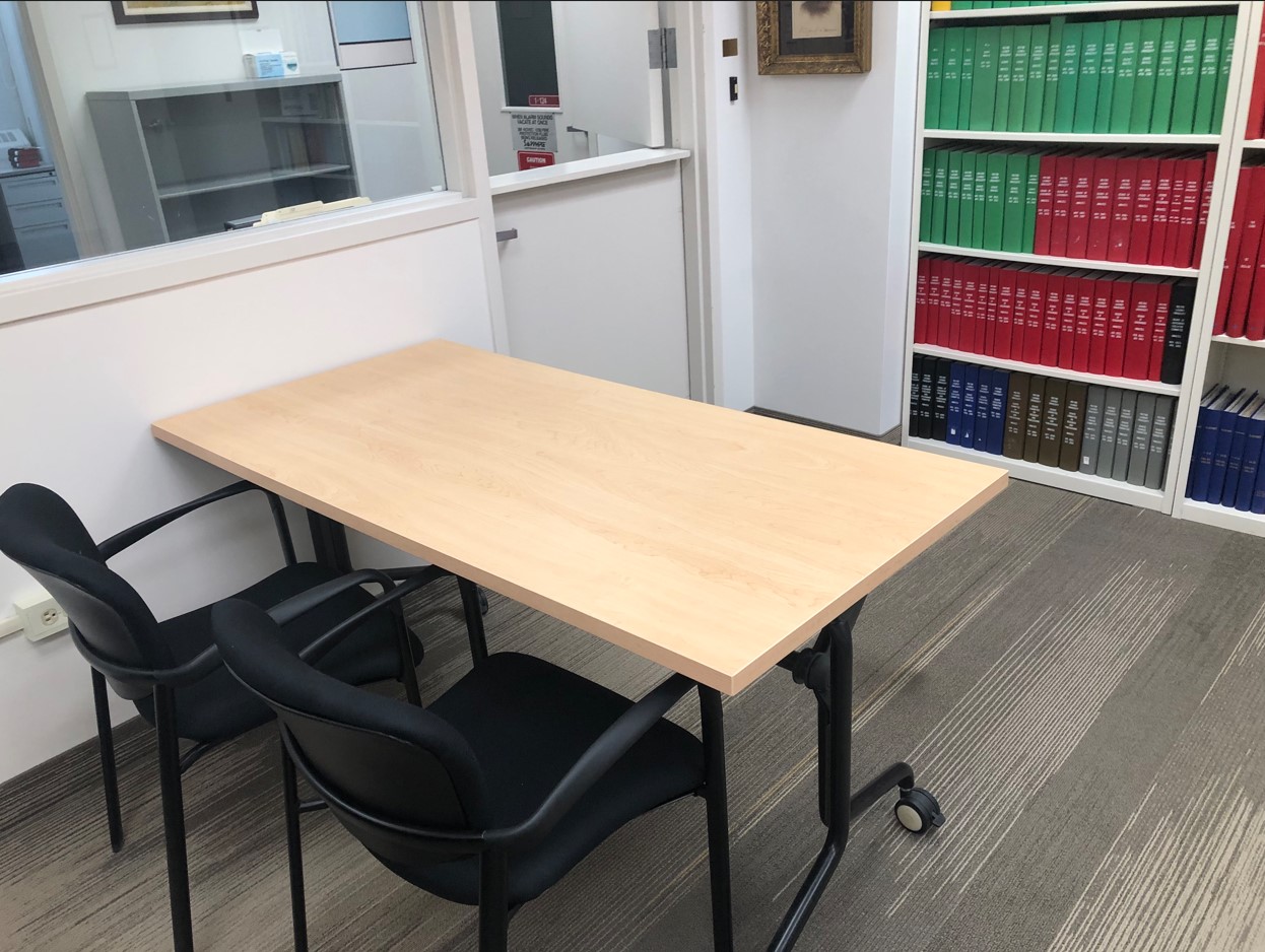 Table on wheels, chairs with arm rests, electronic outlet 1 foot above floor. An observation window allows staff to see into the reading room to ensure patrons are using materials properly