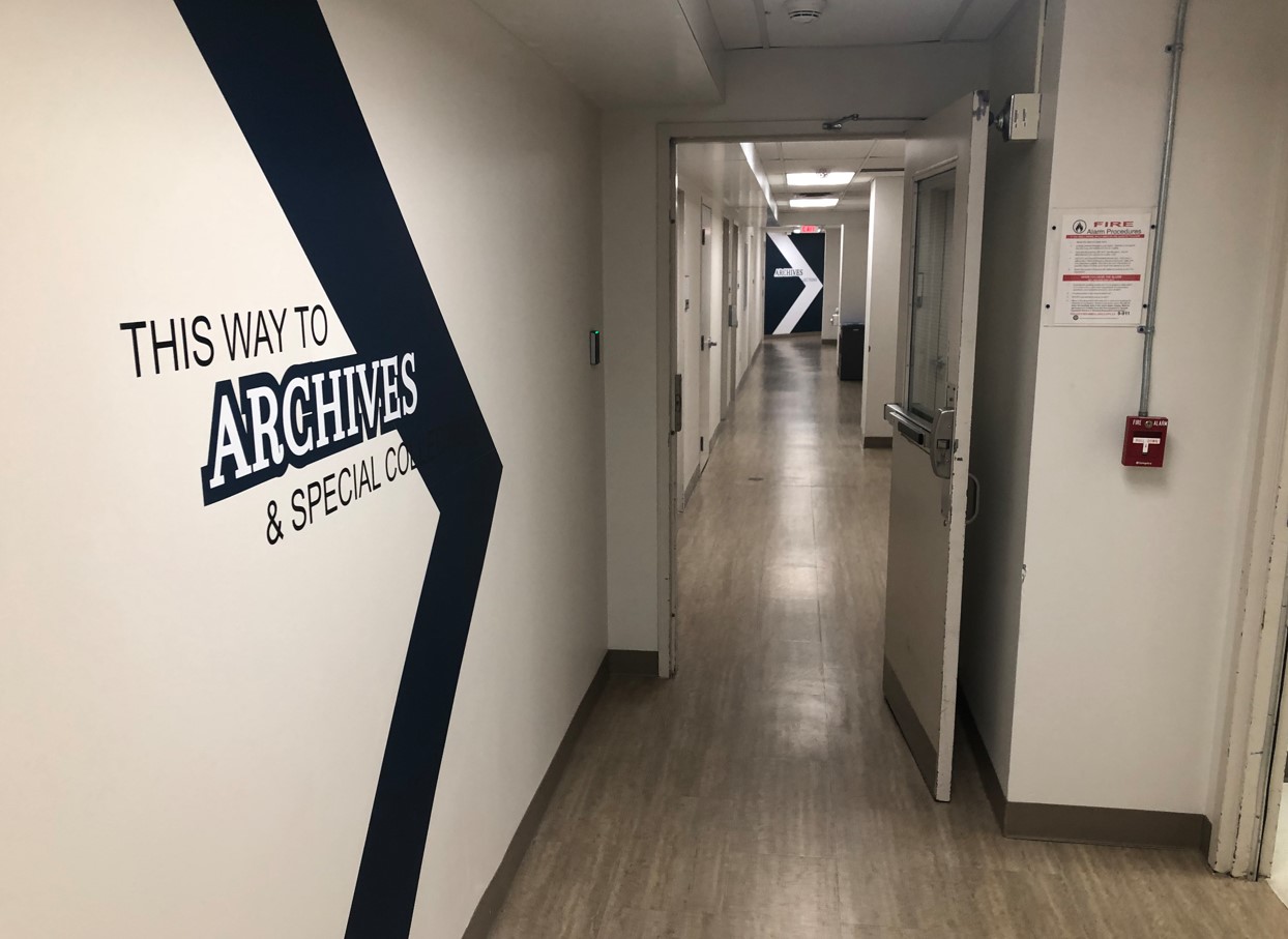 Long hallway with a hallway door kept open during library hours.