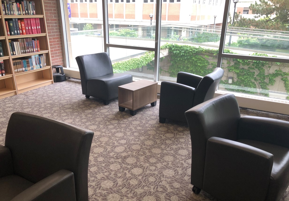 Comfy chairs, some with arm rests, one without, window views to garden and entrance ramp