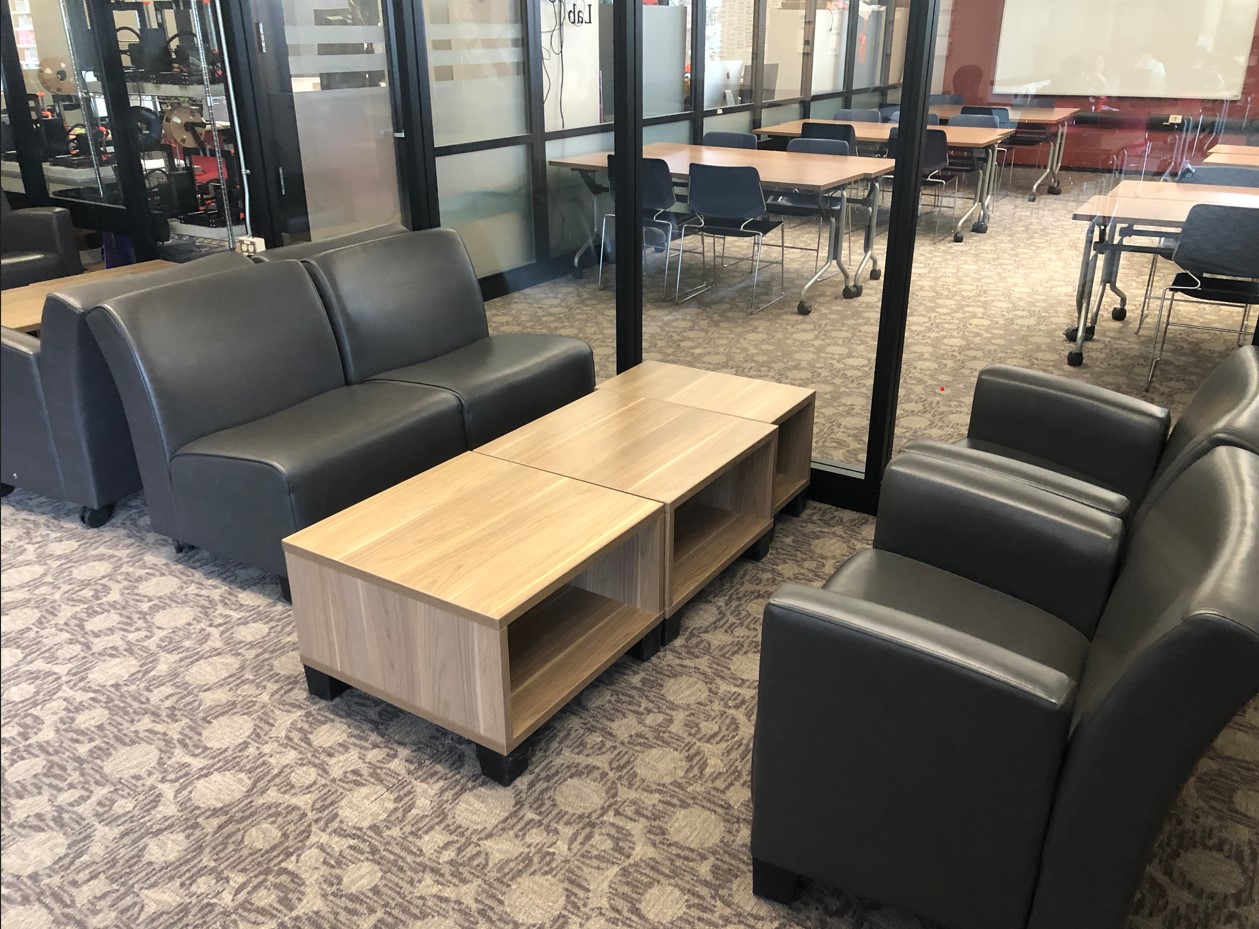 A cluster of comfy chairs, some with arm rests and some not, shine height, moveable coffee table between them