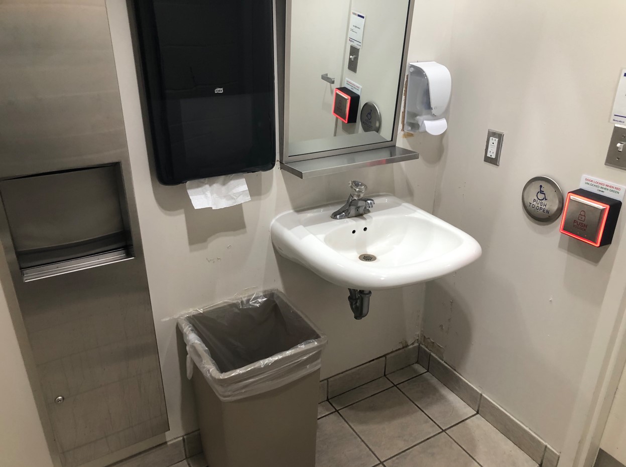 Upon entry, to right: Square button to lock door, soap dispenser, sink, paper towel dispenser, trash bin