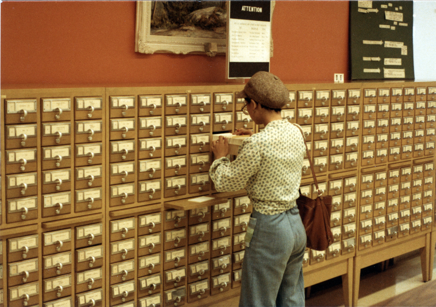 Person opening drawer in library card catalogue
