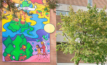40 foot mural on southwest wall . At base of the mural are roots at feet of two Indigenous figures. Bear cubs in trees. Above them is meandering Grand River on which rests a large turtle with two teepees and a fire on its back. Above it is the Dish with One Spoon Wampum. The mural continues upwards out of view. Link to symbolism and teachings in link that follows