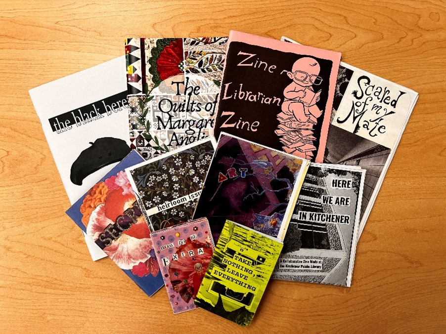 Ten zines of various sizes fanned out on a table. Titles include: Take nothing leave nothing, Here we are in Kitchener, Scared of my Mate.