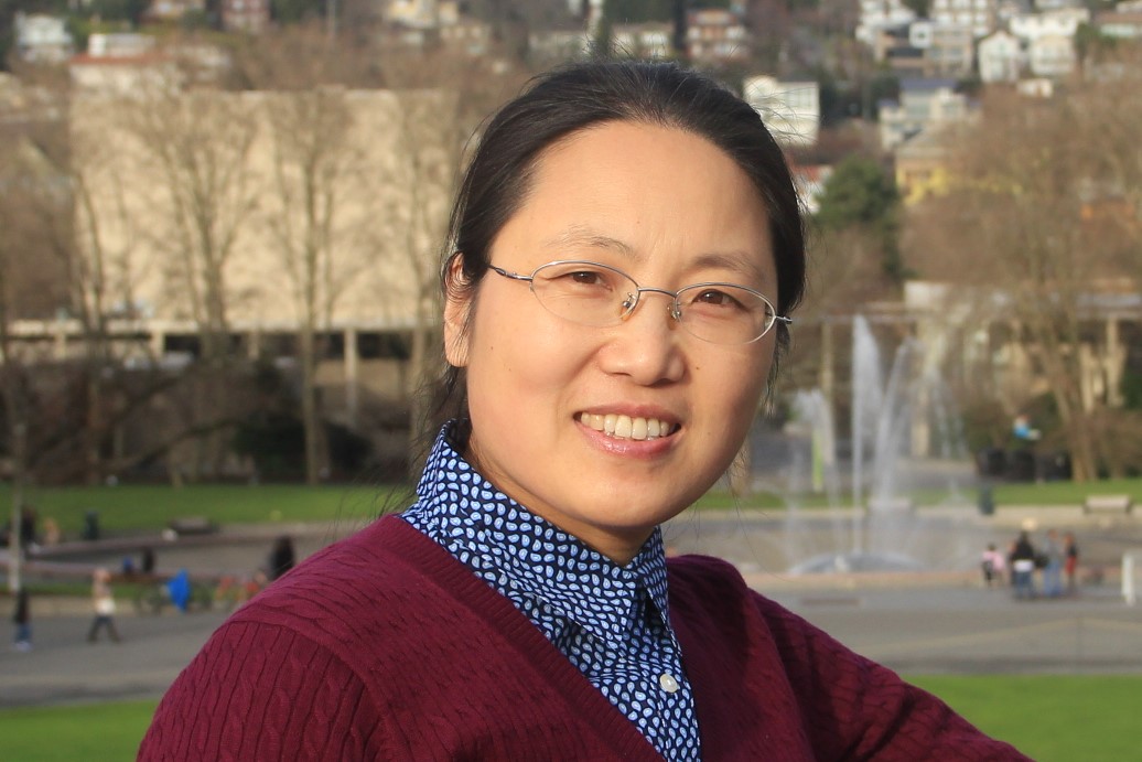 Yanli smiling with a fountain in the background