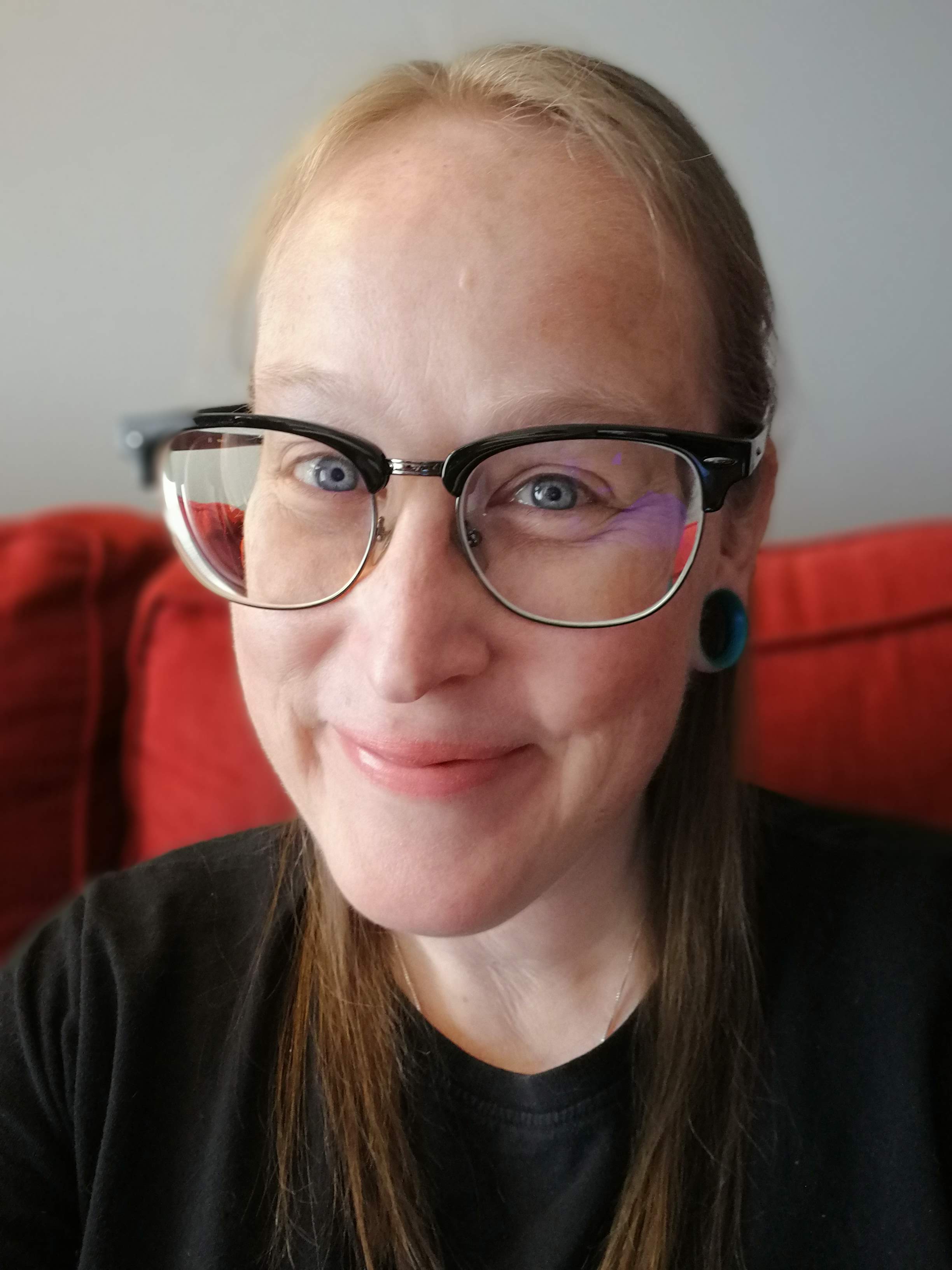 Smiling woman with straight light brown hair and glasses