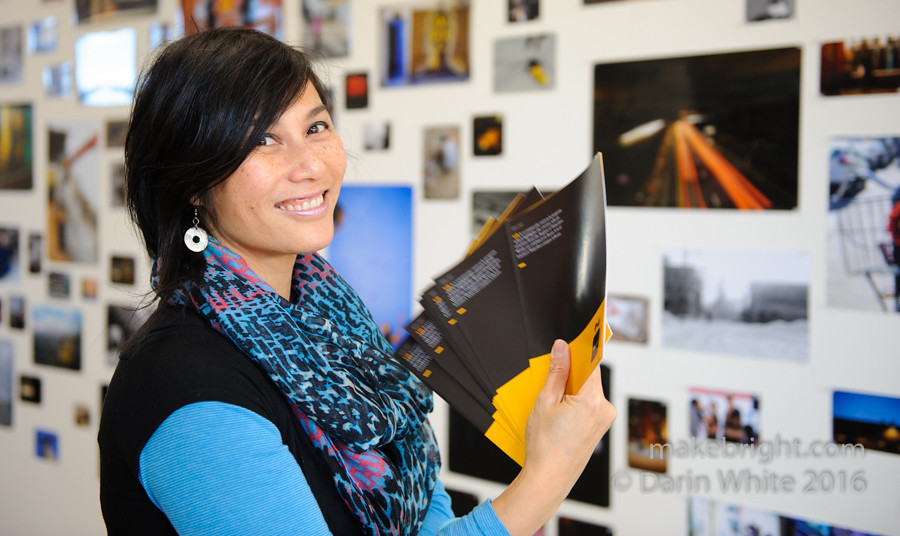 Suzanne Luke holding some brochures from an exhibition