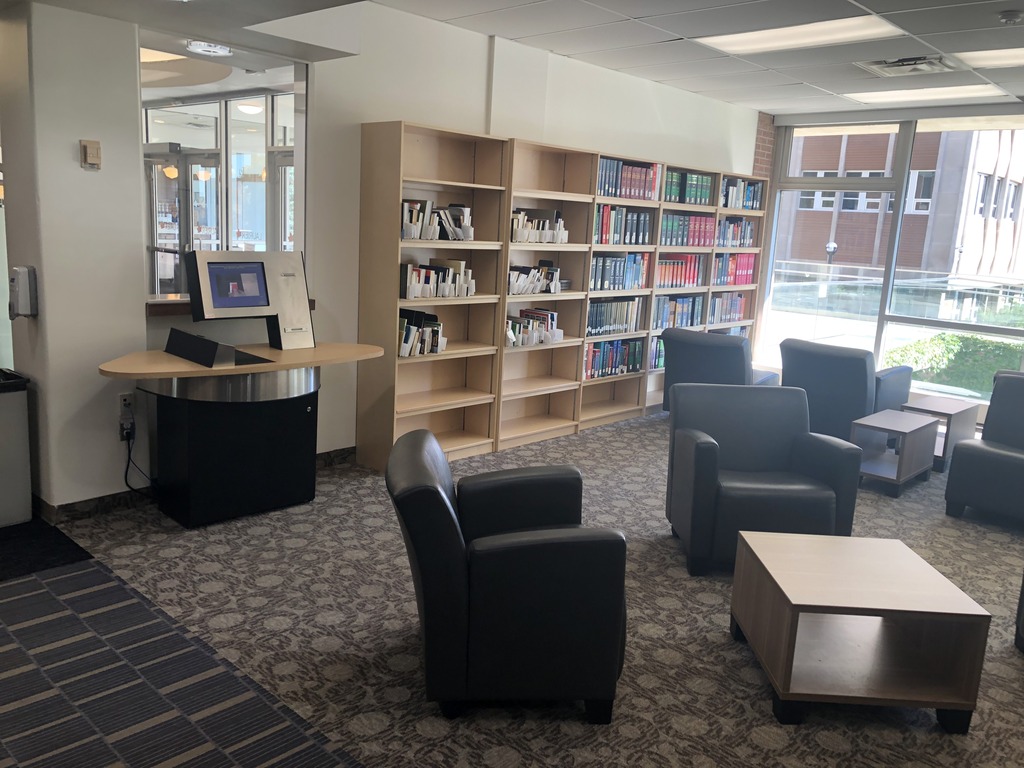 The pickup shelf is next to the entrance near the self-checkout machines. There are movable comfy chairs and movable low tables.